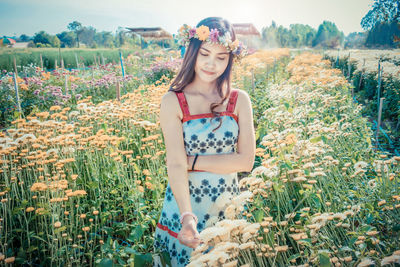 Portrait of beautiful young woman standing on field