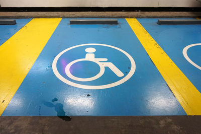 High angle view of wheelchair access sign on floor