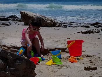 Boy standing on beach against sky