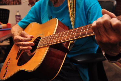 Close-up of man playing guitar