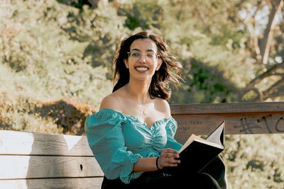 Portrait of smiling young woman sitting outdoors