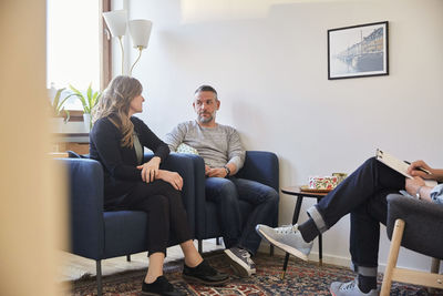 Couple talking while sitting with therapist at community center