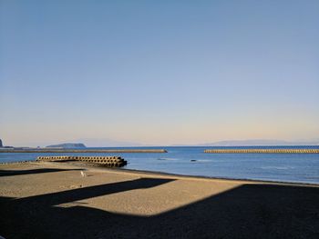 Scenic view of beach against clear blue sky