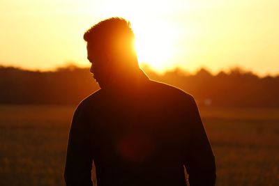 Silhouette man standing against sky during sunset