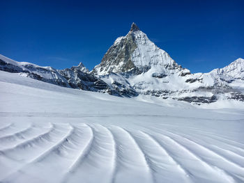 Snow covered mountains against blue sky