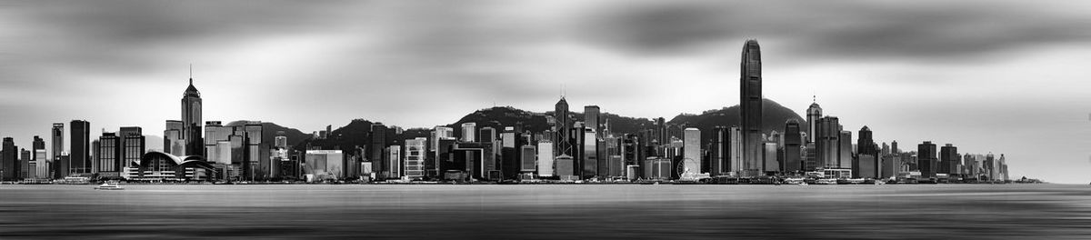 Panoramic view of buildings against cloudy sky