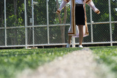 Low section of woman standing by fence