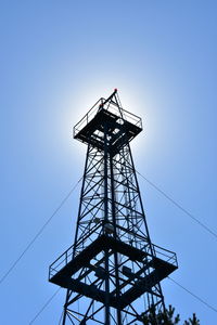 Low angle view of silhouette oil rig against clear sky