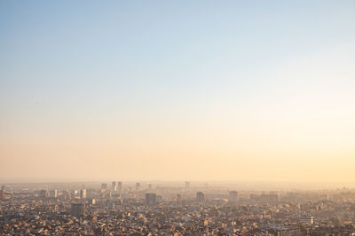 Aerial view of buildings in city against clear sky