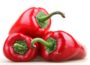 Close-up of red bell peppers against white background