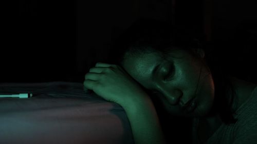 Close-up portrait of teenage girl in darkroom