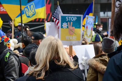 A demonstrator holds sign demanding to stop war in new york city.