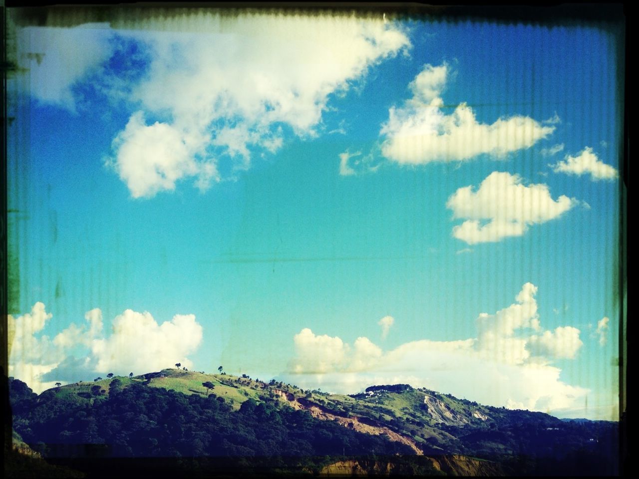 transfer print, sky, auto post production filter, cloud - sky, blue, cloud, tranquil scene, mountain, scenics, tranquility, beauty in nature, cloudy, landscape, nature, low angle view, panoramic, day, outdoors, mountain range, no people