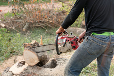 Man working on log in forest