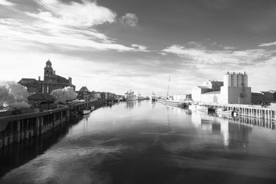 Canal amidst buildings against cloudy sky at great yarmouth