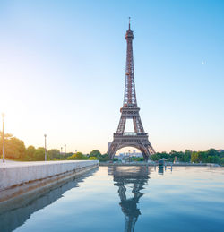 Reflection of eiffel tower in pond against sky