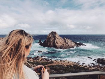 Woman looking at sea against sky