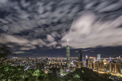 Illuminated cityscape against sky at night