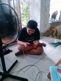 Man using mobile phone while sitting on floor at home