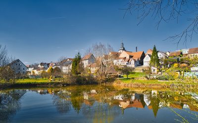 Buildings by lake against sky