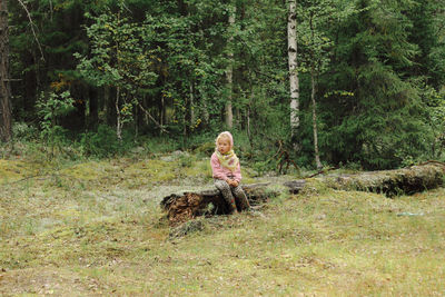 Woman with dog sitting in forest