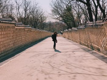 Full length of man walking on bare trees