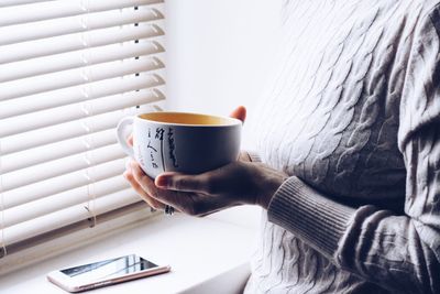 Close-up of hand holding coffee cup