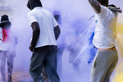 Rear view of people standing against blurred background