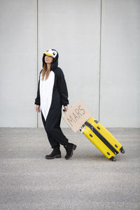 Full length of woman standing against yellow umbrella