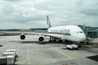 Airplane on airport runway against sky