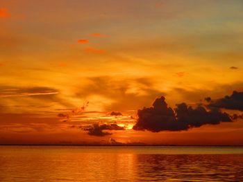 Scenic view of sea against dramatic sky during sunset