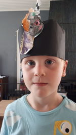 Close-up portrait of cute boy wearing paper crown at home