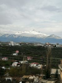 Scenic view of buildings and mountains against sky