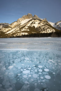 Scenic view of lake and snowcapped mountains against sky