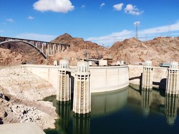 Hoover dam by rocky mountains against sky