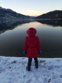 Full length rear view of woman walking on lake during winter