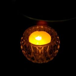 Close-up of lit candle in dark room