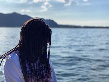 Rear view of woman looking at sea against sky