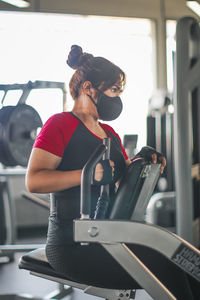 Side view of woman exercising in gym