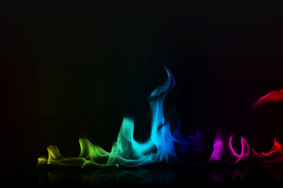 Close-up of lit candles against black background