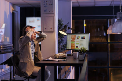 Young woman using mobile phone while sitting in cafe