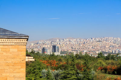 Buildings in city against clear blue sky