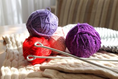 Close-up of multi colored wool balls on table at home