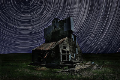Abandoned building on field against sky at night