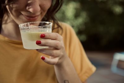 Midsection of woman drinking glass