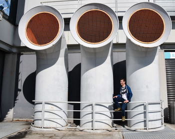 Man sitting against air duct