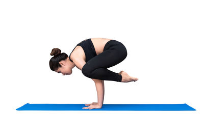 Full length of woman with arms raised against white background