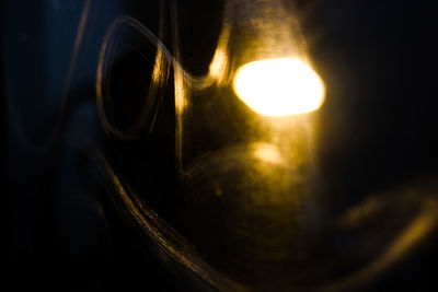 Close-up of illuminated light bulb against sky during sunset