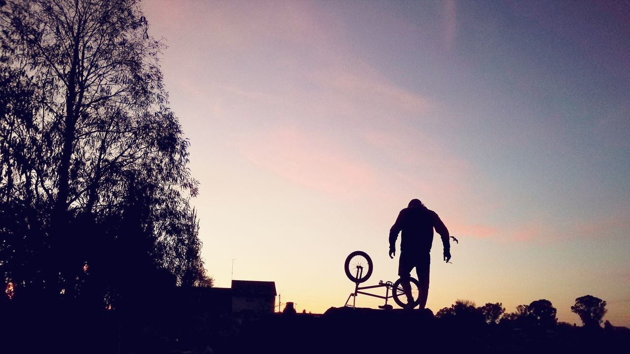 LOW ANGLE VIEW OF SILHOUETTE MAN RIDING BICYCLE