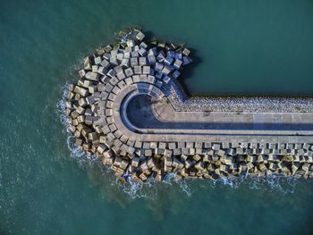 Aerial view of cement blocks protecting the shore from the waves in the port of luanco in asturias.